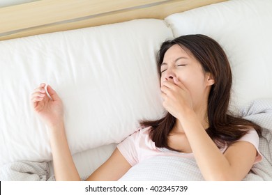 Woman Yawning On Bed