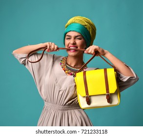 Woman Yelling Screaming And Eating Belt Of Hand Hold Stylish Fashion Yellow Leather Bag Handbag Isolated On Blue Mint Background