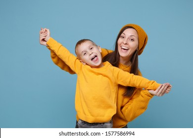 Woman In Yellow Clothes Have Fun Posing With Cute Child Baby Boy 4-5 Years Old. Mommy Little Kid Son Isolated On Blue Background Studio Portrait. Mother's Day Love Family Parenthood Childhood Concept