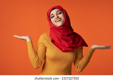 A Woman In A Yellow Dress And Red Hijab Spreads Her Arms To The Side