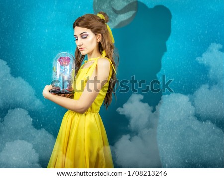 Woman in the yellow dress with red rose in her hands on the background of the beast . Beauty and the beast cosplay art processing. Beauty and the beast cosplay 
