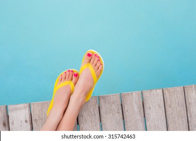 Woman With Yellow Flip Flops By The Pool