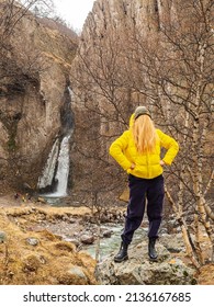 A Woman In A Yellow Jacket With Hair Instead Of A Face Stands Against The Backdrop Of Rocks And A Waterfall In An Autumn Mountain Gorge. Comic Image