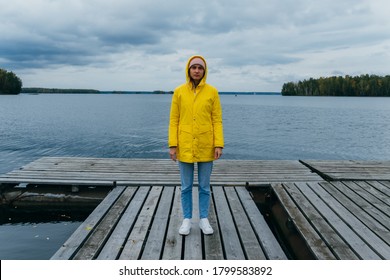 Woman In Yellow Raincoat On The Pier