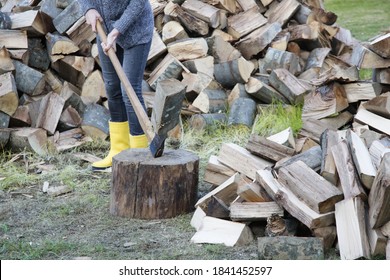 Woman In Yellow Rubber Boots Chopping Woods With Axe. Homestead Chores For The Fall On Farm.