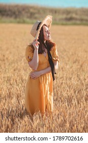 Woman In Yellow Sundress Walking By Wheat Field