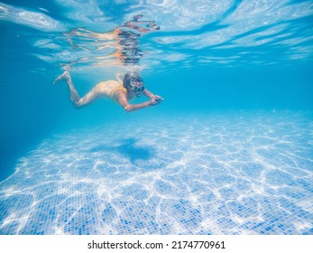 Woman In Yellow Swimming Suit In Clear Blue Water In Pool