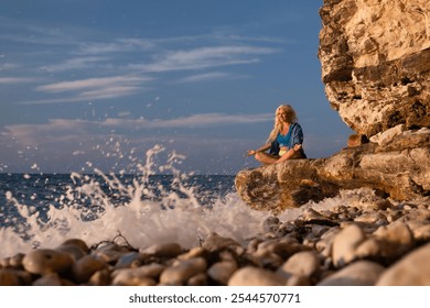 Woman Yoga Beach Ocean Sunset Meditation - A woman practices yoga on a rocky beach as the sun sets over the ocean. - Powered by Shutterstock