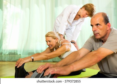 Woman Yoga Instructor Showing New Asana To Smiling Mature Couple 