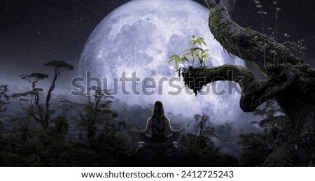 Woman in yoga position meditating in tropical jungle with big moon