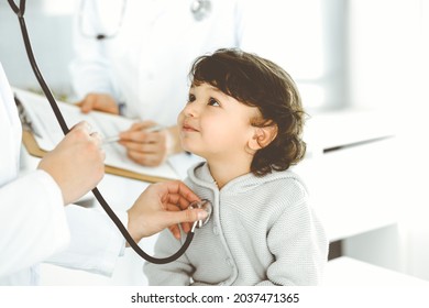 Woman-doctor Examining A Child Patient By Stethoscope. Cute Arab Toddler At Physician Appointment. Medicine Concept