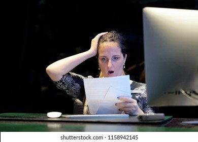 A Woman-reception Hotel Worker Reading Negative News In Letter. Shocked Beauty Girl Business Manager Received Layoff Message Letter From Company Feeling Surprised. An Agitated Girl Without Joy.