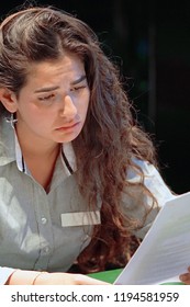 A Woman-reception Hotel Worker Reading Negative News In Letter. Shocked Beauty Girl Business Manager Received Layoff Message Letter From Company Feeling Surprised. An Agitated Girl Without Joy.