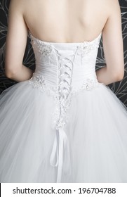 Woman's Back In White Wedding Dress With Corset. Closeup