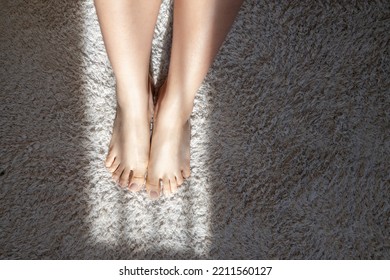 Woman's Bare Feet From Above On White Fluffy Carpet On Floor With Sun Rays. Modern Apartment, Bath, Bedroom, Kitchen Decor Details. Minimal Concept. 