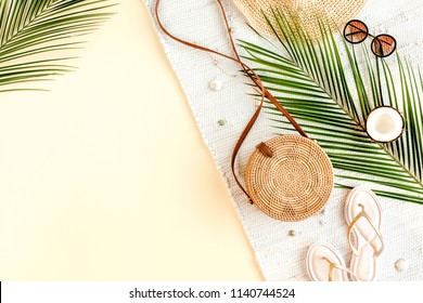 Woman's Beach Accessories:  Rattan Bag, Straw Hat, Tropical Palm Leaves On Yellow Background. Summer Background. Flat Lay, Top View.