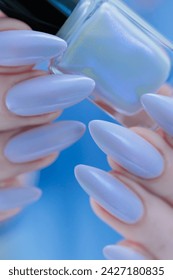 Woman's beautiful hand with long nails and light baby blue manicure: stockfoto