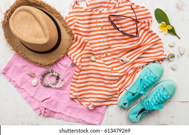 Woman's Casual Summer Clothes With Accessories Items On White Rustic Wooden Board Background, Overhead Top View, Flay Lay