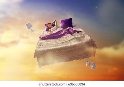 Woman's dreams. Pretty girl is flying in her bed trough star sky. - Shutterstock ID 636533834