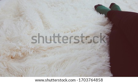Woman's feet laying in bed on a soft blanket