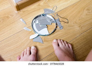 Woman's Feet Near Shards Of Broken Mirror On A Floor At Home