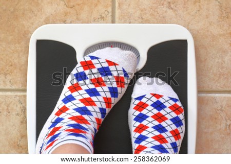 Woman's feet on bathroom scale. Diet concept