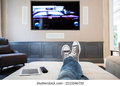 Woman's Feet On Ottoman Watching TV