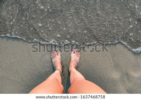 Woman's feet on a sandy beach, time for summertime !