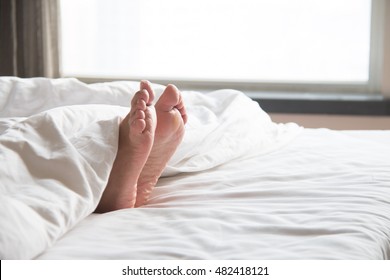 Woman's feet in the quilt - Powered by Shutterstock