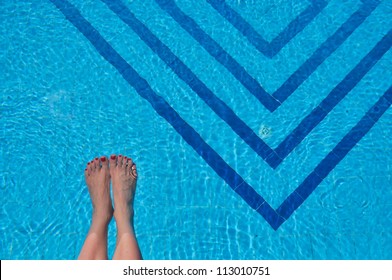 Woman's Feet In A Swimming Pool