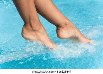 Woman's feet in a swimming pool under water jets
