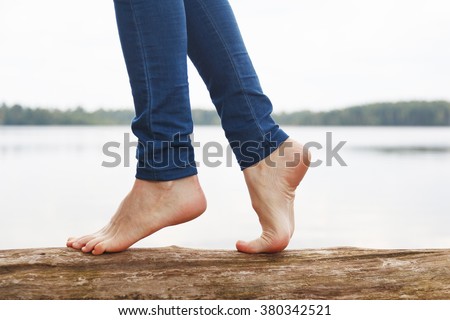 Woman's feet walking on a log