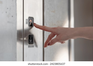 Woman's finger pressing the elevator button
