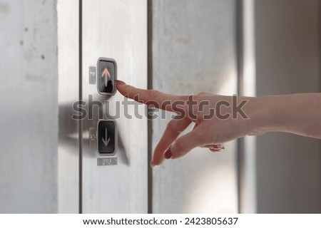 Woman's finger pressing the elevator button