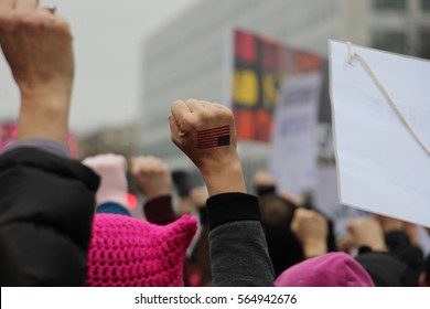 Woman's fist with US flag raised in the air at Women's March in Washington DC
