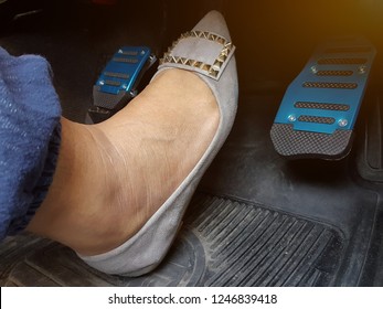 A Woman's Foot Depressing The Brake Pedal Of A Car.