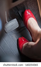 A Woman's Foot Depressing The Brake Pedal Of A Car.