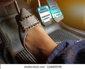 A Woman's Foot Depressing The Clutch Pedal Of A Car.