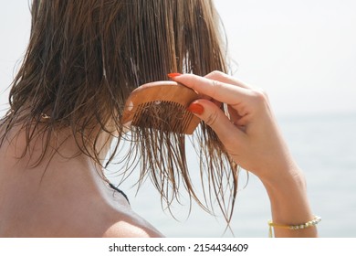 Woman's Hair On The Beach. Woman Applaying Hair Mask With Wooden Comb. Hair Damage Due To Salty Ocean Water And Sun, Summertime Hair Care Concept.