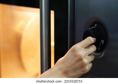 Woman's hand adjusting electric oven in kitchen, closeup                          - Shutterstock ID 2215518715