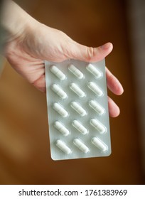 Woman's Hand And Blister Card With White Pills