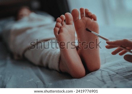 Woman's hand brushes feet of sleeping baby