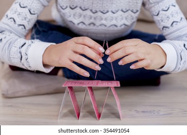 Womans Hand Building A House Out Of Cards