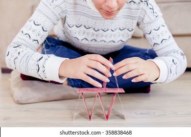 Womans Hand Building A House Out Of Cards