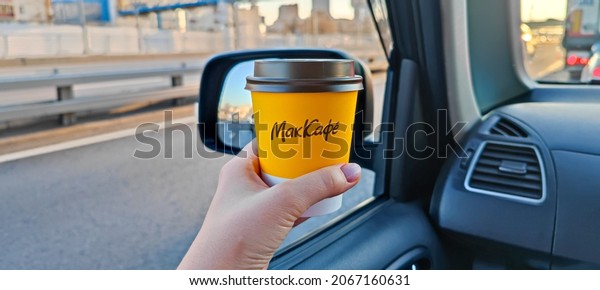 In a
woman's hand, in the car, a cardboard glass from McDonald's with
hot tea or coffee. McCafe is on the road with a cappuccino. Morning
with coffee in traffic. Russia, Moscow,
30.10.2021