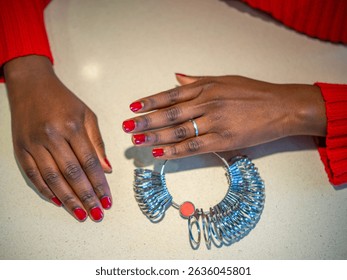 Woman's hand choosing the correct ring size with a ring sizer.