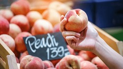 Woman's Hand Choosing Peach Fruit In Supermarket