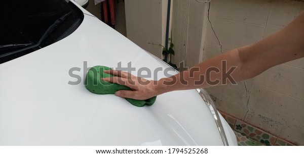 The woman\'s hand is\
cleaning the car