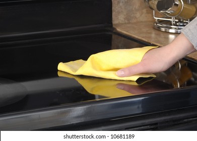 Woman's Hand With A Cloth Cleaning Ceramic Cooktop