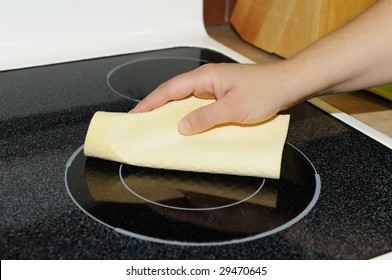 Woman's Hand With A Cloth Cleaning Ceramic Cooktop